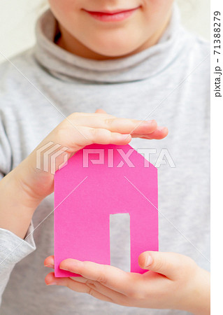 Closeup of paper house in hands of child. 71388279