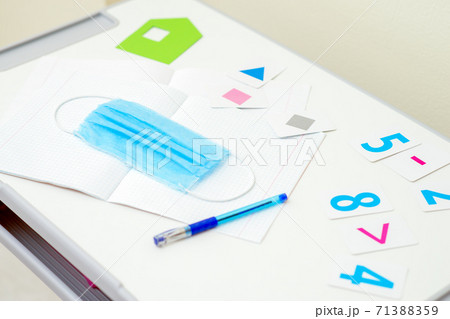 Medical mask with pen over copybook. 71388359