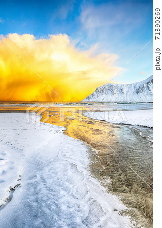 Fabulous winter scenery on Skagsanden beach with illuminated clouds during sunrise. 71390269