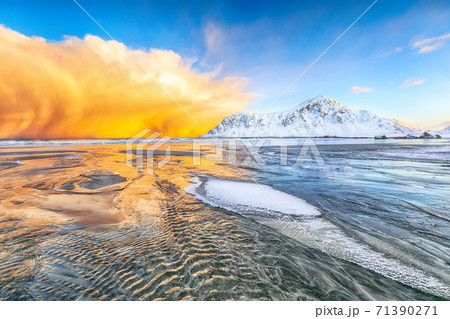 Fabulous winter scenery on Skagsanden beach with illuminated clouds during sunrise. 71390271