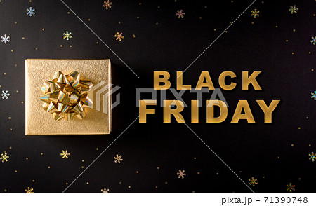 Top view of golden christmas gift boxes on black background with Black Friday text. Black Friday Sale, Banner, poster composition. 71390748