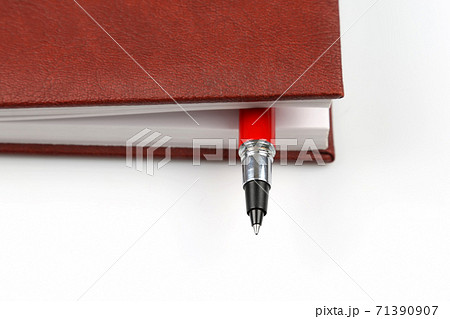 the red pen is inside the notebook. the red pen is inside the notebook. 71390907