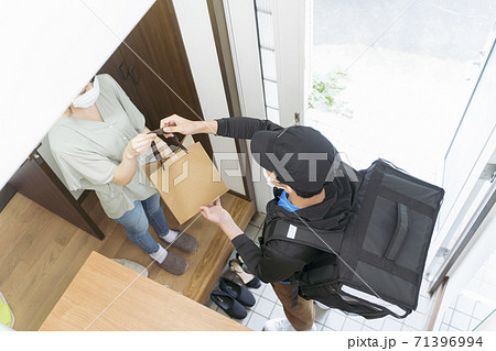玄関でデリバリー を受け取る女性 玄関でデリバリー を受け取る女性 71396994