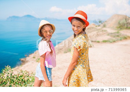 Little happy funny girls have a lot of fun at tropical beach playing together Little happy funny girls have a lot of fun at tropical beach playing together 71399365