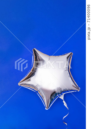 A silver glitter foil star shaped balloon on blue 71400096