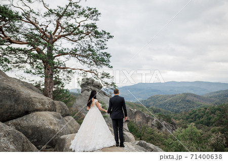 Beautiful gorgeous bride posing to groom and having fun near at mountains with amazing view, space for text, wedding couple Beautiful gorgeous bride posing to groom and having fun near at mountains with amazing view, space for text, wedding couple 71400638