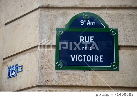 Closeup of Victory street name on the traditional parisian street plate on stoned building - (rue de la victoire in french) Closeup of Victory street name on the traditional parisian street plate on stoned building - (rue de la victoire in french) 71400685