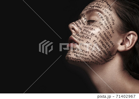 Portrait of beautiful girl with painted words on her face. Art make-up. 71402967