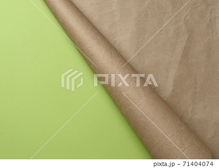 folded corner of a roll of brown paper on a green background 71404074