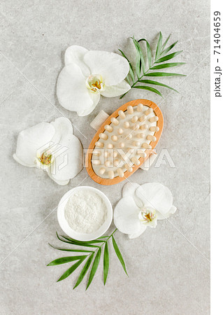 Spa treatment concept. Natural spa cosmetics products, sea salt, massage brush, tropic palm leaves on gray marble table from above. Spa background Spa treatment concept. Natural spa cosmetics products, sea salt, massage brush, tropic palm leaves on gray marble table from above. Spa background 71404659
