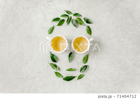 Cup of fresh green tea with tea leaves. Flat lay, top view. Tea concept Cup of fresh green tea with tea leaves. Flat lay, top view. Tea concept 71404712