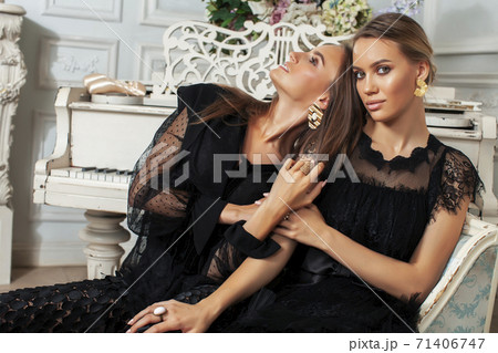 two young pretty lady in black lace fashion style dress posing in rich interior of royal hotel room, luxury lifestyle people concept 71406747