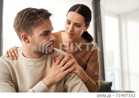 Supportive woman embracing her depressed husband Supportive woman embracing her depressed husband 71407352