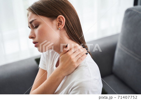Woman massaging stiff sore neck Woman massaging stiff sore neck 71407752