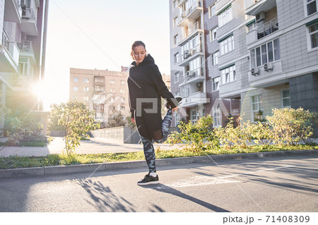 Woman warming up before a morning workout Woman warming up before a morning workout 71408309
