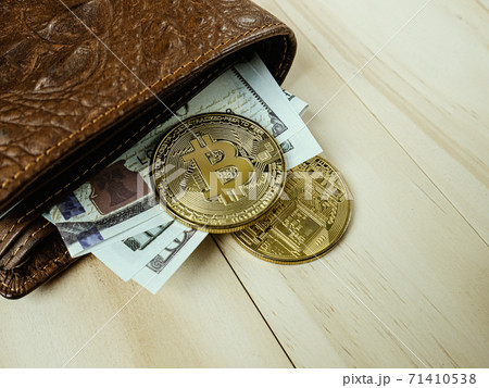 The bitcoin in Crocodile leather wallet  on  wood table. 71410538