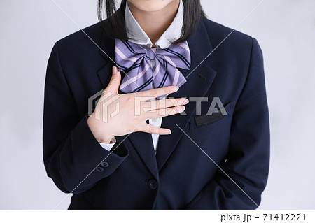 制服の女子高生が胸に手を当てている Girl Student Uniformの写真素材