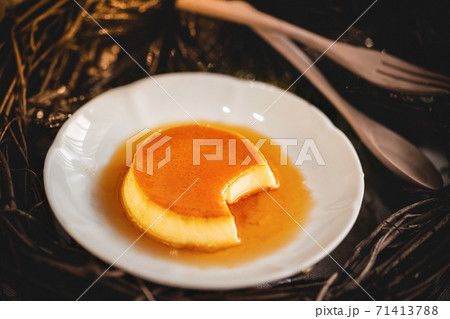 Homemade caramel custard pudding on white plate with wood background Homemade caramel custard pudding on white plate with wood background 71413788