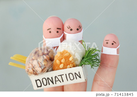 Fingers art of family with face mask. Man and woman holding donation box with food. Fingers art of family with face mask. Man and woman holding donation box with food. 71413845