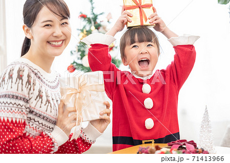 ファミリー クリスマスプレゼントを交換する親子の写真素材