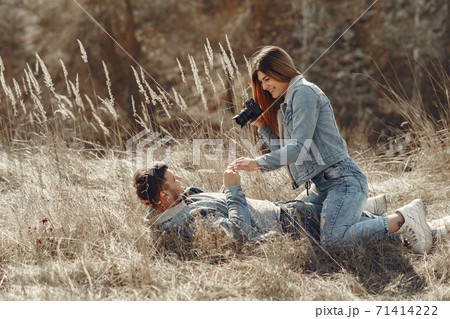 Cute couple in a jeans clothes in a spring field Cute couple in a jeans clothes in a spring field 71414222