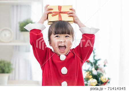 クリスマスプレゼントをもらって喜ぶ女の子の写真素材