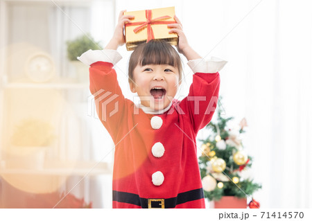 クリスマスプレゼントをもらって喜ぶ女の子の写真素材