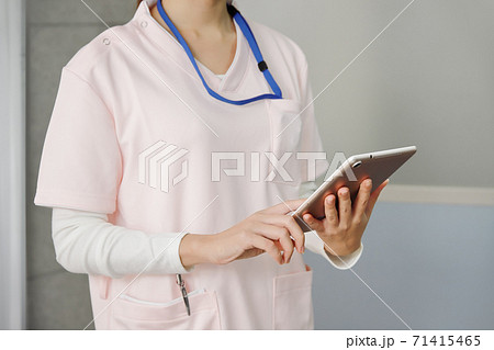 タブレットを操作する医療従事者の女性 71415465