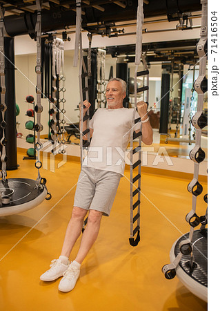 A man hanging on gym machine and looking positive A man hanging on gym machine and looking positive 71416504
