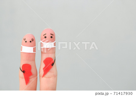 Fingers art of couple in medical mask from COVID-2019. Concept of couple holding broken heart. Fingers art of couple in medical mask from COVID-2019. Concept of couple holding broken heart. 71417930