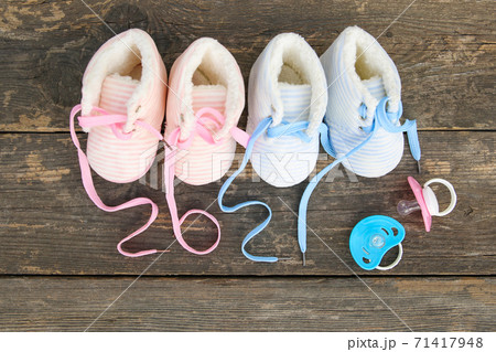 2021 new year written laces of children's shoes and pacifier on old wooden background.  71417948
