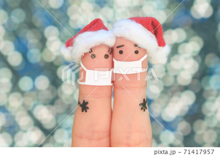 Fingers art of couple in medical mask from COVID-2019 celebrates Christmas. Fingers art of couple in medical mask from COVID-2019 celebrates Christmas. 71417957