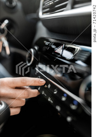 Interior view of a modern new car. Woman's hand and climatronic or air conditioner system concept. 71420742