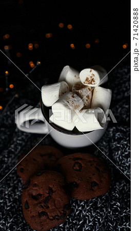 Mug with marshmallows and chocolate chip cookies on dark Christmas background 71420888