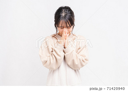 お願いのジェスチャーをする若い女性 71420940