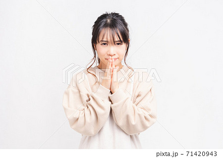お願いのジェスチャーをする若い女性 71420943