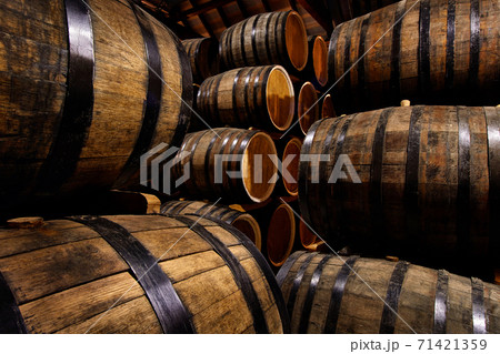 Rows of alcohol barrels in stock. Distillery. Cognac, whiskey, wine, brandy. Alcohol in barrels 71421359