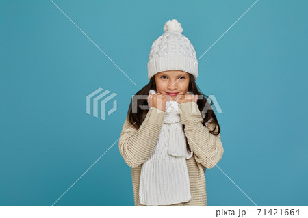 cheerful child girl in white winter knitted hat cheerful child girl in white winter knitted hat 71421664
