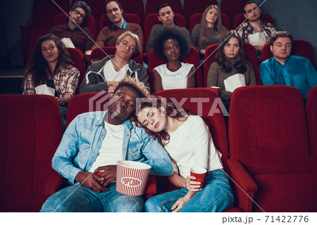 Multiethnic couple in love is sleeping in cinema. Multiethnic couple in love is sleeping in cinema. 71422776