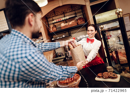 Smiling Girl Giving Package with Bread to Man. Smiling Girl Giving Package with Bread to Man. 71422965