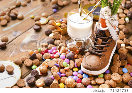 Dutch holiday postcard Sinterklaas. Wooden background with childrens shoe with carrots for Santa's Dutch holiday postcard Sinterklaas. Wooden background with childrens shoe with carrots for Santa's 71424753