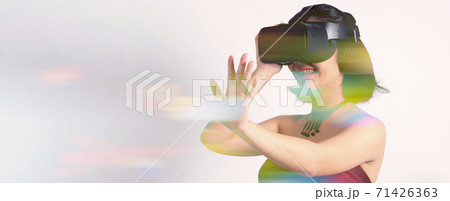 Asian teenage woman wearing VR or Virtual Reality head set and enter to the digital simulation world for learning and traveling or gaming and more. Studio shot white background Asian teenage woman wearing VR or Virtual Reality head set and enter to the digital simulation world for learning and traveling or gaming and more. Studio shot white background 71426363
