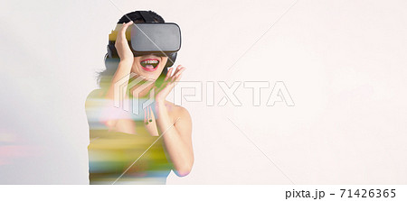 Asian teenage woman wearing VR or Virtual Reality head set and enter to the digital simulation world for learning and traveling or gaming and more. Studio shot white background Asian teenage woman wearing VR or Virtual Reality head set and enter to the digital simulation world for learning and traveling or gaming and more. Studio shot white background 71426365