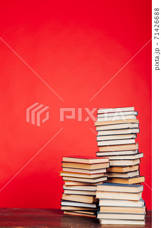 many stacks of educational books for exams in the library on a red background 71426688