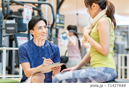 ジムのトレーナーと若い女性 ジムのトレーナーと若い女性 71427689