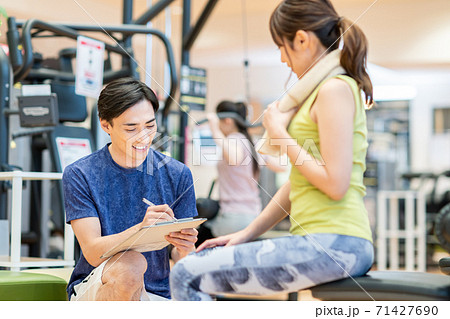 ジムのトレーナーと若い女性 71427690