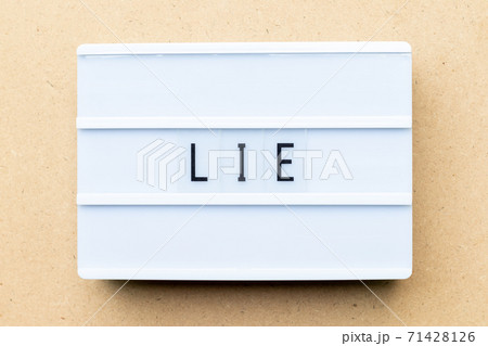 White lightbox with word lie on wood background White lightbox with word lie on wood background 71428126