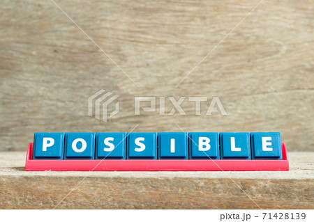 Tile letter on red rack in word possible on wood background Tile letter on red rack in word possible on wood background 71428139