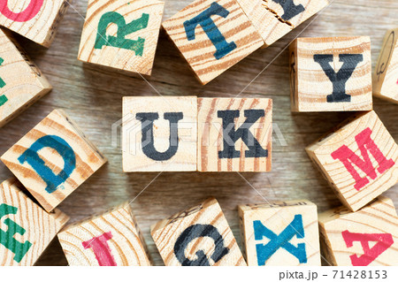 Alphabet letter block in word UK  (abbreviation of united kingdom) with another on wood background 71428153