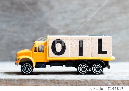 Truck hold letter block in word oil on wood background 71428174